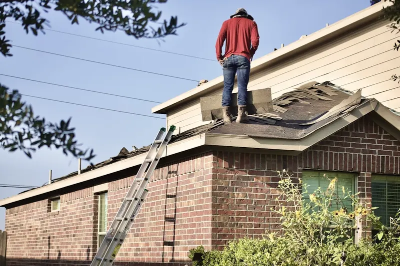 Professional roofer working on a residential roof in Monitor